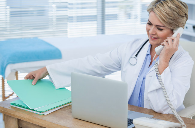 Stock photo of doctor talking on phone at desk